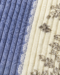 Close-up of blue ivory ribbed floral panel comforter fabric